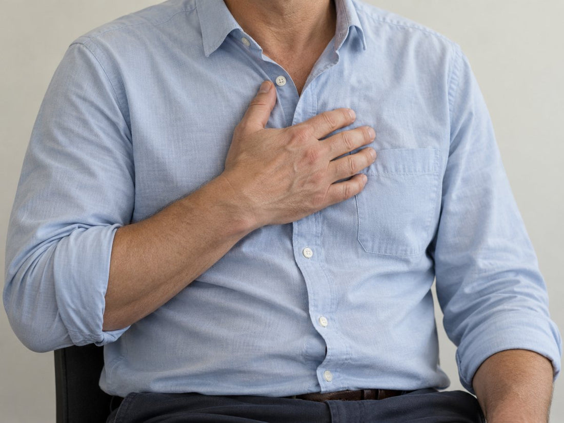 Close-up of an adult in a blue shirt resting a hand on their chest.